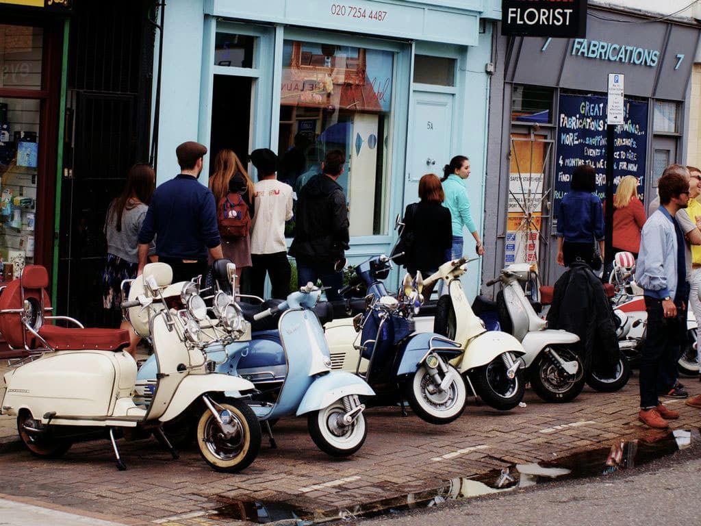Vintage scooters parked outside shops on Broadway Market, Hackney