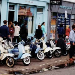 Vintage scooters parked outside shops on Broadway Market, Hackney