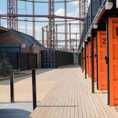 Timber walkway past orange container doors at Containerville