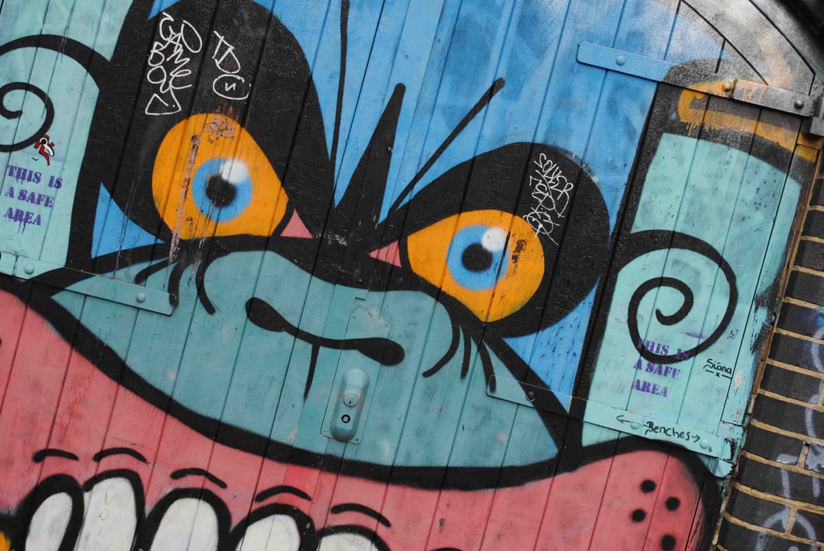Colourful street art mural with a large painted eye at Containerville, Hackney
